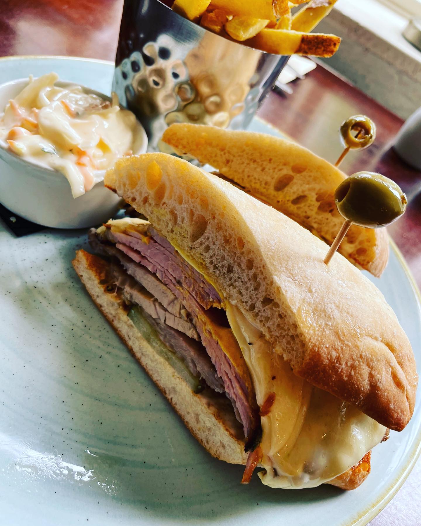 Cuban style toasted sandwich, roasted pork shoulder, honey glazed ham, thick cut pickles, Swiss cheese & American mustard on a toasted ciabatta
